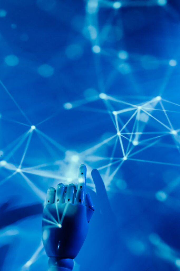 pexels-photo-8386437 Futuristic robotic hand touching a digital network on a blue background.